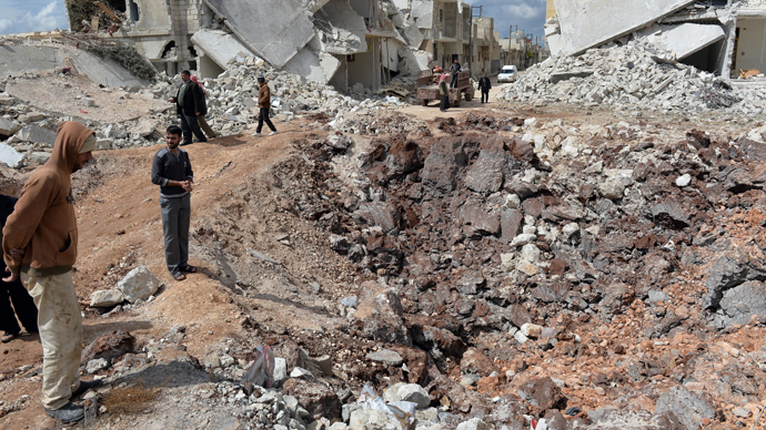 People walk past destroyed houses in the northern Syrian town of Azaz (AFP Photo)
