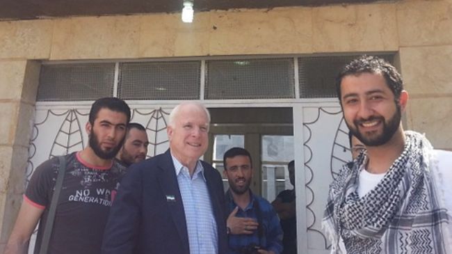 Hawkish US Senator John McCain (C) poses with infamous kidnapper in Syria, Mohamed Nour (seen with his hand on his chest and holding a camera)
