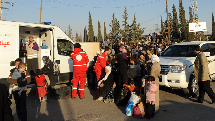 A handout picture released by the official Syrian Arab News Agency (SANA) on October 12, 2013 shows Syrian women and children arriving to be evacuated by Syria's Red Crescent from a Damascus suburb (AFP Photo)